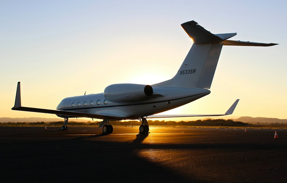 Private jet flying above clouds at golden hour